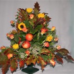 Chêne, soleils et roses sont complétés par des végétaux de jardins et des pommes pour le coeur du bouquet.