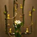 Pommier de Noël construit sur un  arbre en espalier. Les pommes vertes sont décorées de dentelle et les jaunes servent de vases.