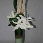 Sur un vase haut et élancé, les lys blancs ressemblent à des fleurons d'orchidée.