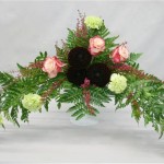 Oeillets, roses et 3 dahlias pompons pourpres dans un élégant vase en opaline.