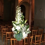 Deux bouquets hauts sur des supports en osier à l'accueil du cortège à l'entrée de l'église.