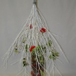 Le fagot de branches est posé à l'envers sur un vase haut et stable.