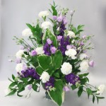 Giroflées violettes, lisianthus mauves, oeillets blancs et hostas variegata pour le point focal du bouquet triangulaire.