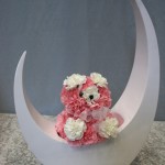 Pompons d'oeillets roses et blancs forment une peluche de fleurs.