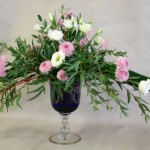 Sur un verre bleu et précieux le romantisme s'exprime en petites fleurs roses et blanches.